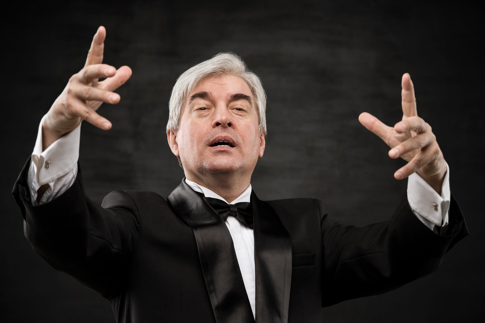 Closeup portrait of male orchestra conductor directing with his hands